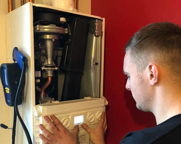 Working on the boiler settings when servicing the gas boiler.