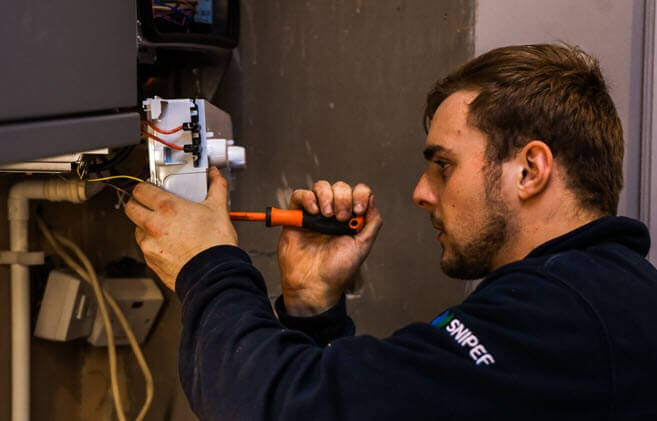 Celsius plumber undertaking a boiler repair in Edinburgh.