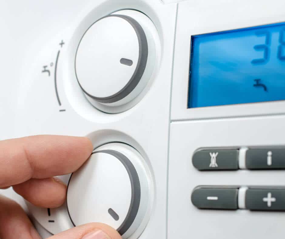 Customer adjusting a boiler dial in an Edinburgh home.