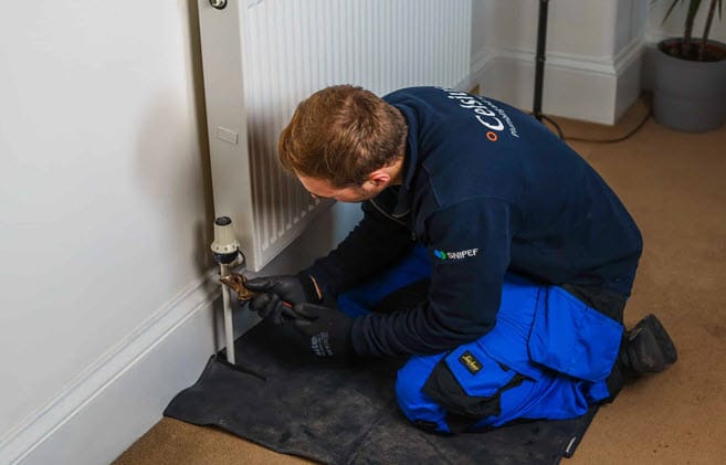 Celsius heating engineer repairing a central heating radiator.