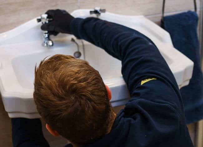 Plumber undertaking a tap repair in Edinburgh.