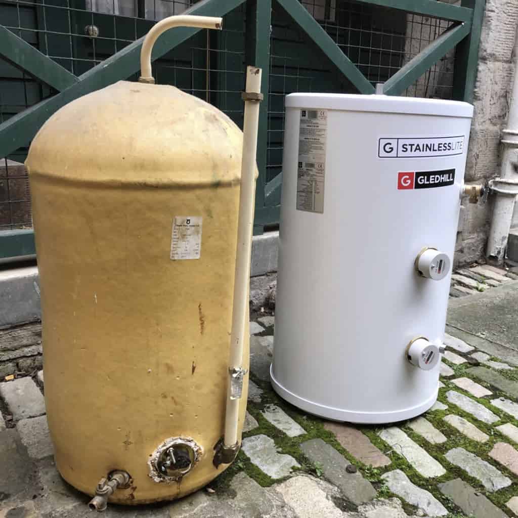 New hot water tank next to an old fashioned hot water cylinder.